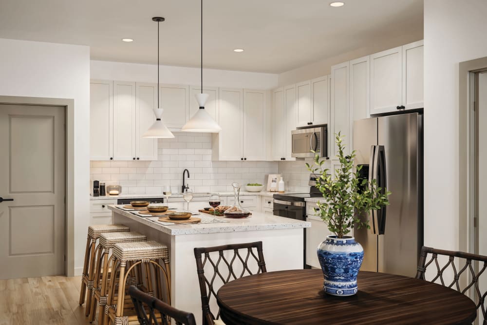 Downtown Pensacola, FL, Luxury Apartments Near Palafox - The Romero - Modern Kitchen With White Cabinetry, Island Seating, Pendant Lights, and Stainless Steel Appliances.