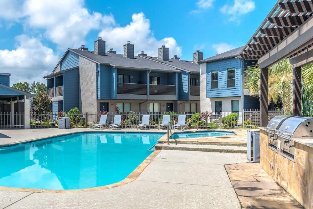 Swimming pool with multiple lounge chairs at The Brighton in Houston, Texas