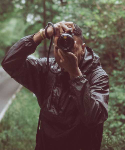 Person taking a photo with a camera near St. Albans Lofts in Raleigh, North Carolina