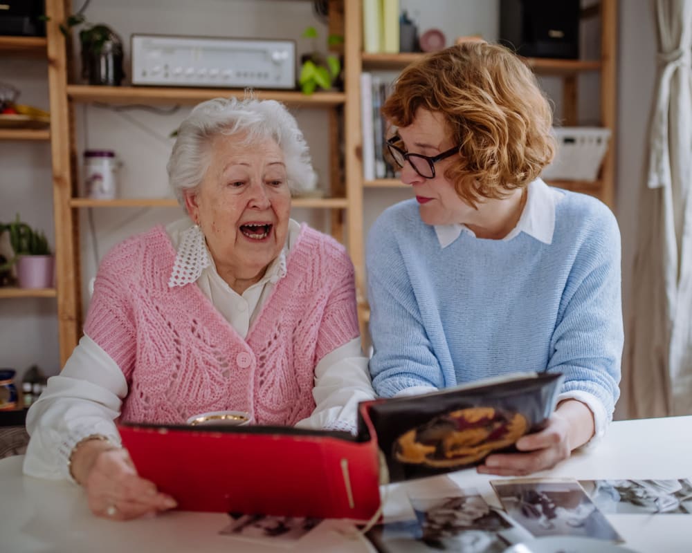 A staff member and resident looking through a book at Bayberry Commons in Springfield, Oregon