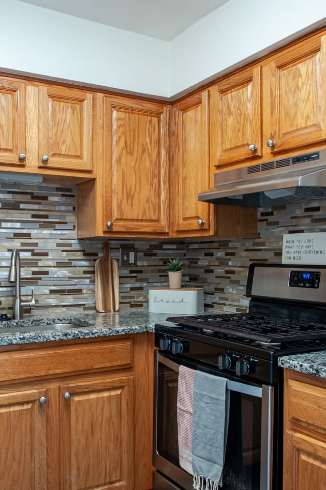Kitchen with appliances and maple cabinets at Chesterfield Apartment Homes in Levittown, Pennsylvania
