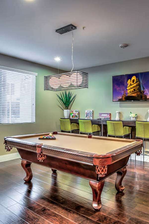 Game room with pool table, wood-style flooring, modern lighting, and green bar stools at Duet in Las Vegas, Nevada