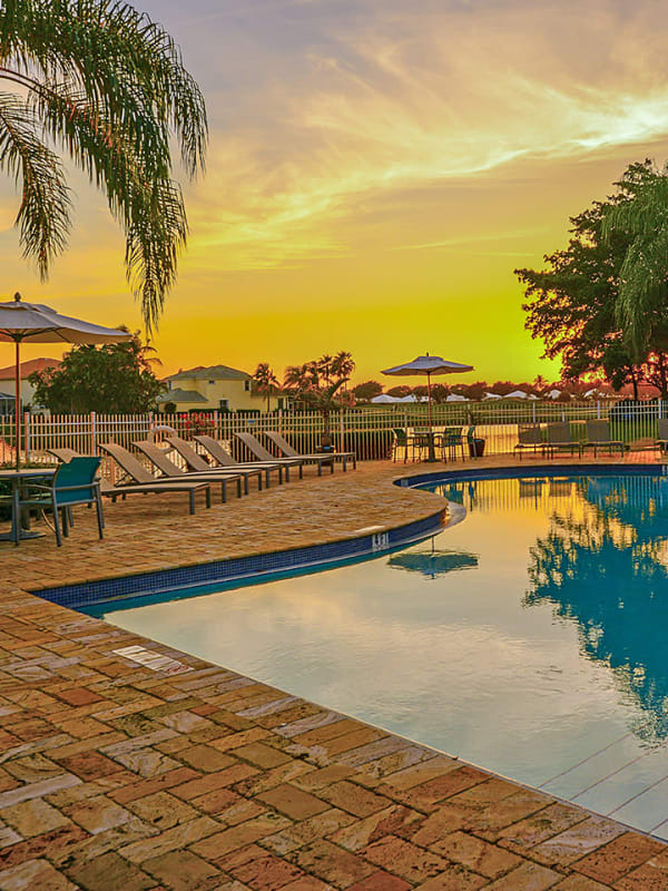 Resort-style swimming pool and sundeck at sunset at Royal St. George at the Villages Apartment Homes in West Palm Beach, Florida