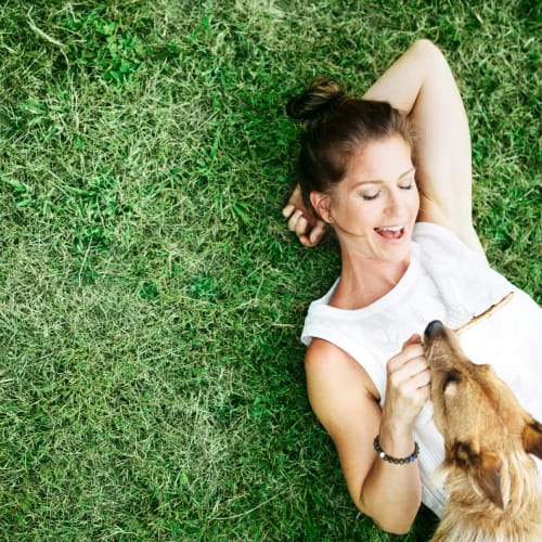 A resident laying in the grass with a dog at Challenger Estates in Patuxent River, Maryland