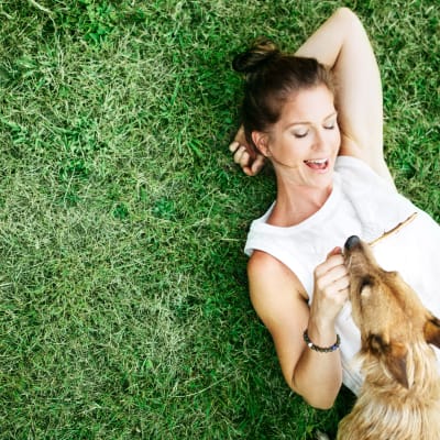 Woman laying in grass with dog at Stanley Court in Portsmouth, Virginia