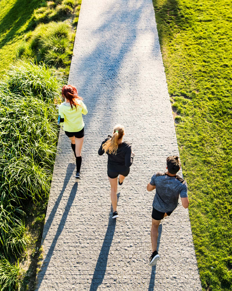 A group of friends running through a park near Residence at Marathon in Columbus, Georgia