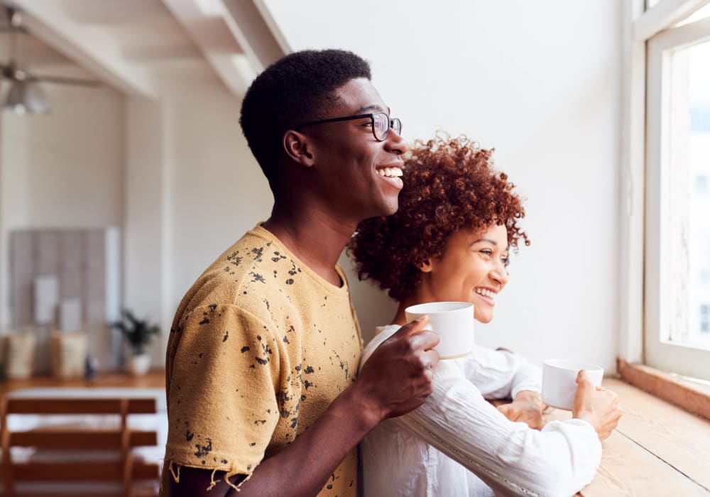 Couple enjoying coffee while looking out the window at Glen Hollow Apartments in Glen Burnie, Maryland