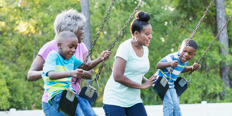 Children and their parents playing on swings at a playground near JFSC in Norfolk, Virginia