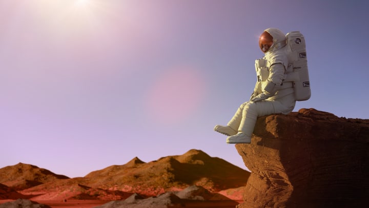Astronaut on planet Mars sitting on a ledge
