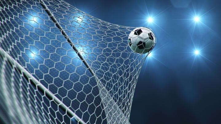 A soccer ball hits the net at the back of a goal