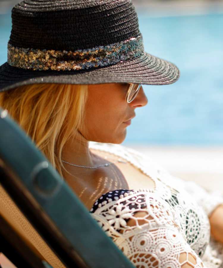 Woman relaxing by the pool at Shalimar at Plantation in Plantation, Florida