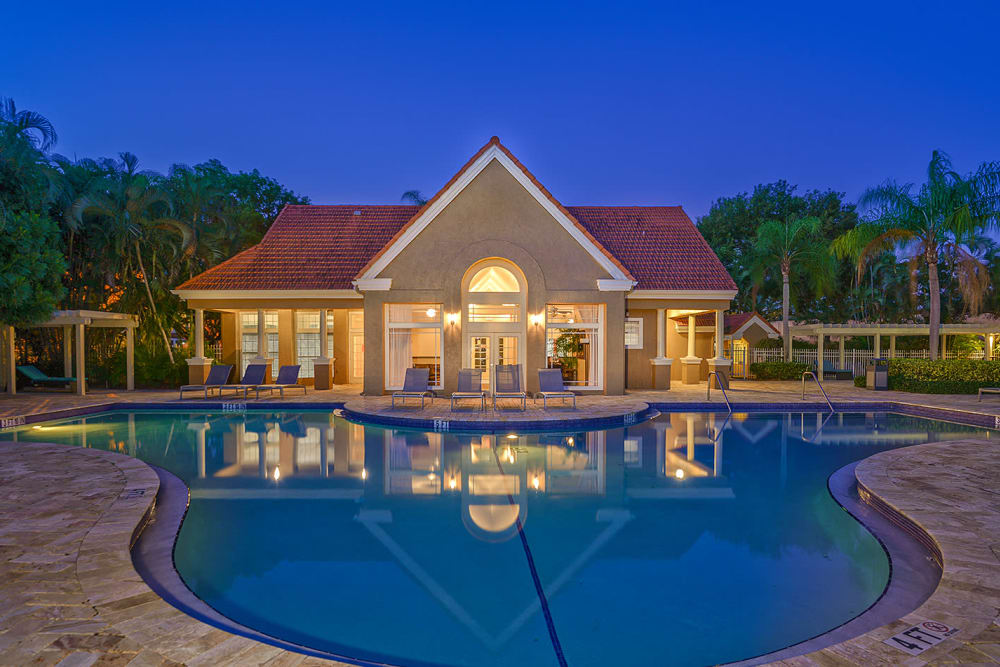 Resort-style swimming pool at twilight at Royal St. George at the Villages Apartment Homes in West Palm Beach, Florida