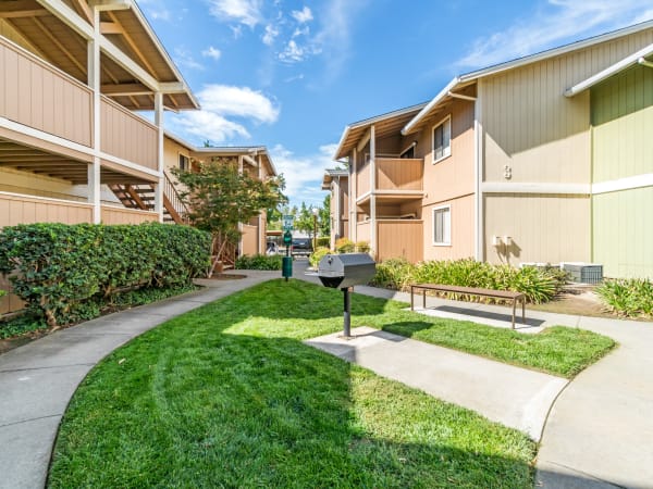 Exterior Building and Walkway shot with BBQ and Lush landscaping Sommerset Apartments in Vacaville