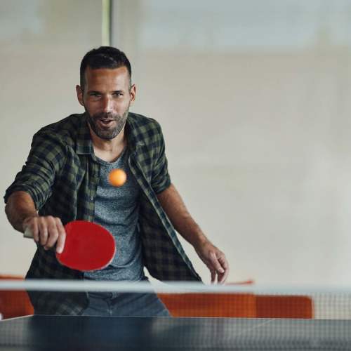 Resident playing table tennis in clubhouse at Emerald Place in Lancaster, Ohio