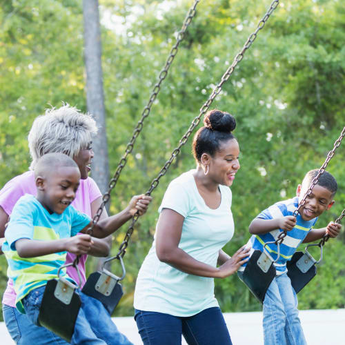 A mother  pushing  his son on swing at park near Town Center in Joint Base Lewis McChord, Washington