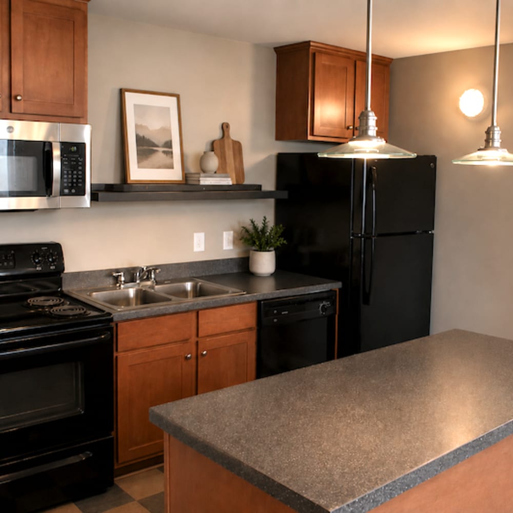 Kitchen with black appliances and island at Stockbridge Apartments in Des Moines, Iowa