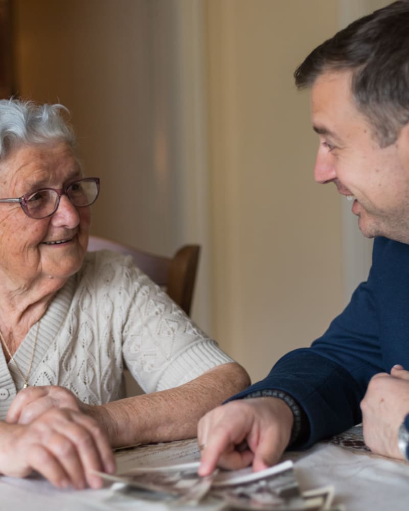 Resident and caretaker looking at photos at Keepsake Village at Greenpoint in Liverpool, New York