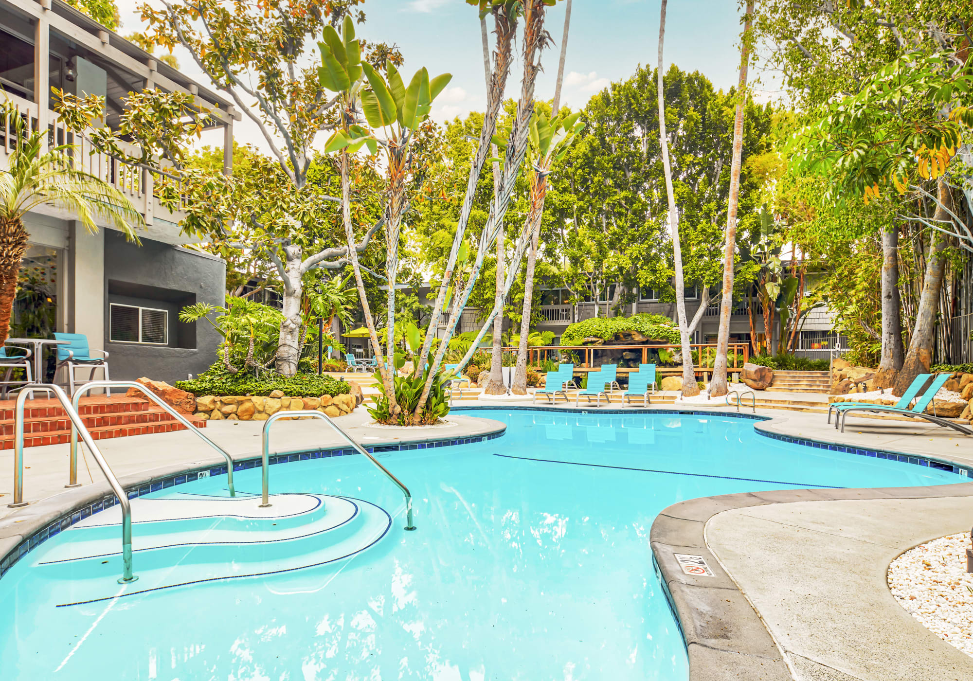 Resort-style swimming pool surrounded by mature trees at Rancho Los Feliz in Los Angeles, California