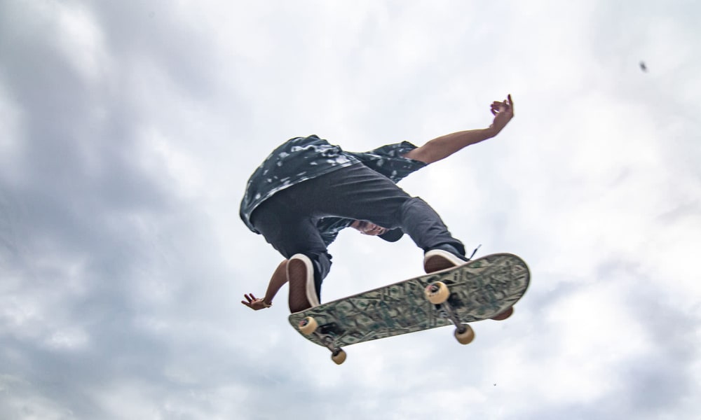 Young man jumping with skateboard near 33 North in Denton, Texas