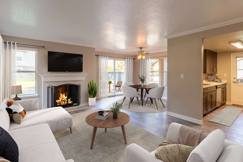 Living room with fireplace and kitchen at Seventeen Mile Drive Village Apartment Homes in Pacific Grove, California