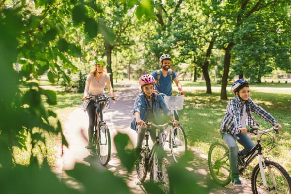 Family enjoying riding bikes in the park near Springhouse Townhomes in Allentown, Pennsylvania