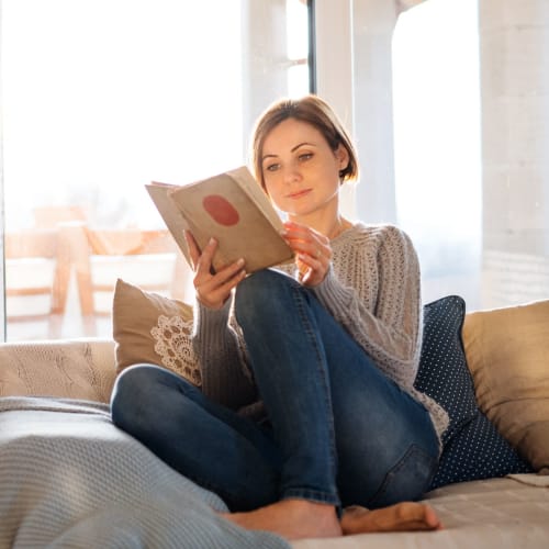 A resident reading on a couch at Midway Manor in Virginia Beach, Virginia