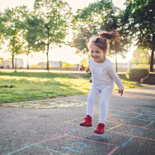 A child playing hopscotch in a park near Eagleview in Joint Base Lewis McChord, Washington