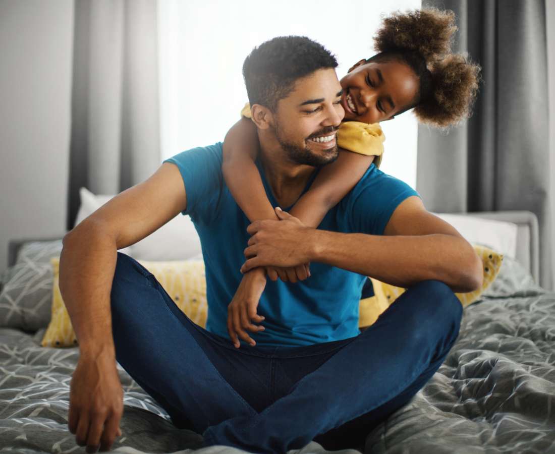 A resident sitting on the bed with his daughter and having a good time at Prosper 83 in Sparks, Nevada