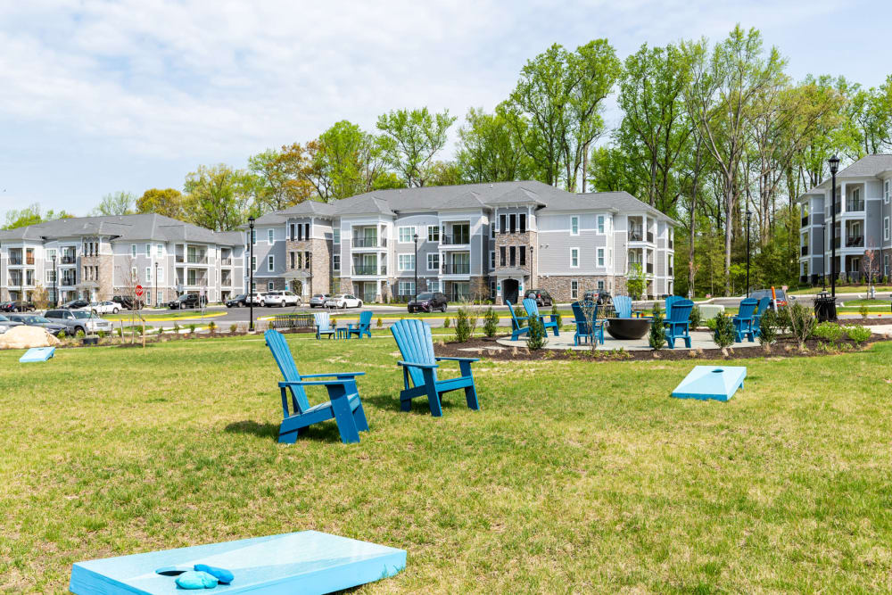 Cornhole and firepit surrounded by Adirondack chairs on the lawn at Boulders Lakeside in North Chesterfield, Virginia