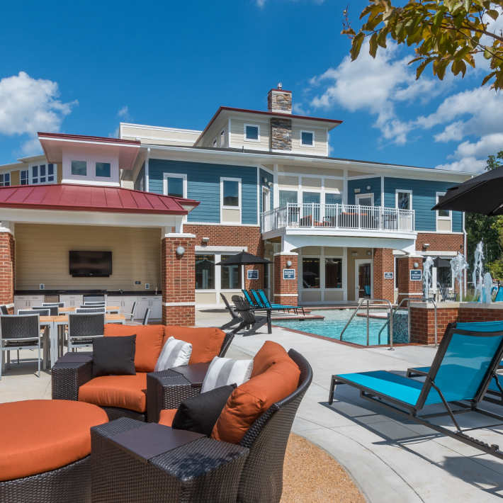 Patio area next to pool with barbeque and chairs at Attain at Quarterpath, Williamsburg, Virginia