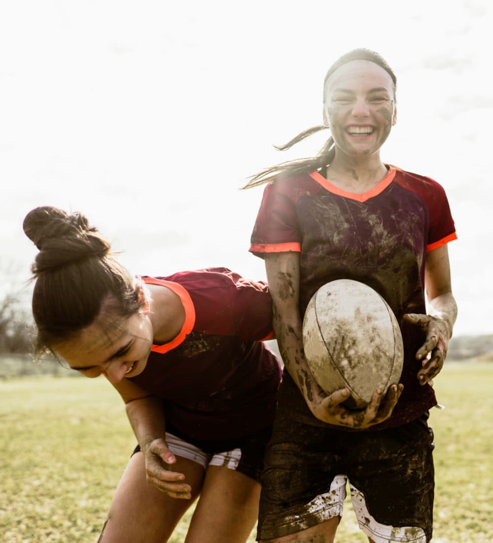 Members of the women's rugby team laughing during practice near The Foundry in Ames, Iowa
