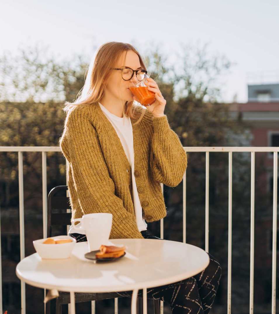 Resident having breakfast in her private balcony at The Garnett in Brooklyn, New York