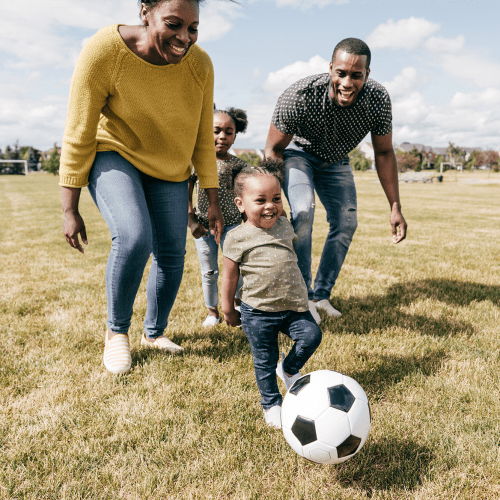 A family playing with a soccer ball in a park near Capeharts in Ridgecrest, California