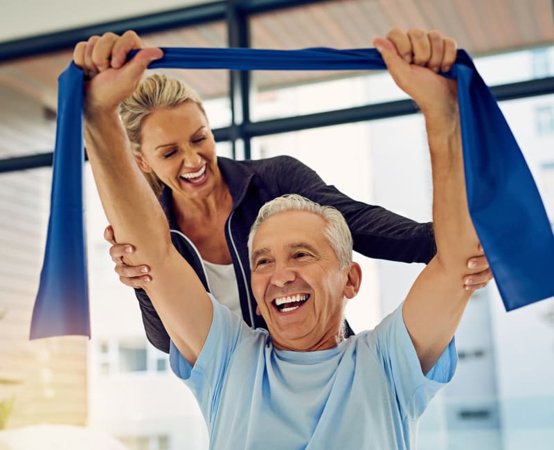 Resident training with a resistance band and the help of an instructor at Meadows on Fairview in Wyoming, Minnesota