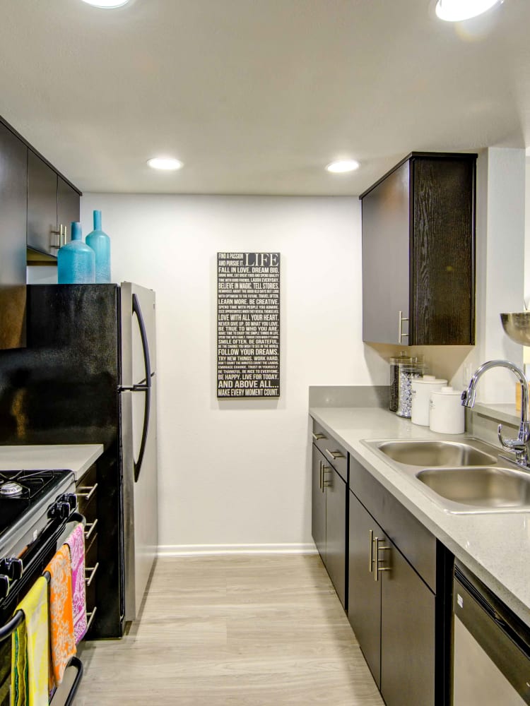 Spacious kitchen with granite countertops and recessed lighting in a model home at Sofi at 3rd in Long Beach, California
