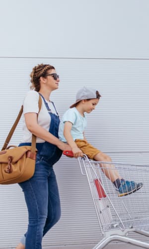 Mother pushing her son in a grocery cart as they run errands near The Majestic at Hewitt in Hewitt, Texas