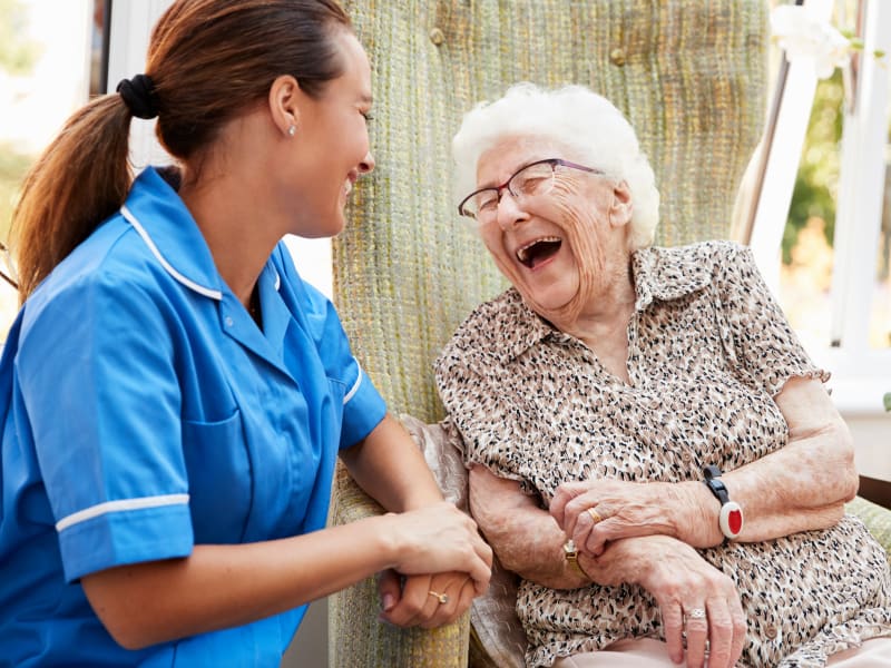 A staff member laughing with a resident at Timber Pointe Senior Living in Springfield, Oregon. 