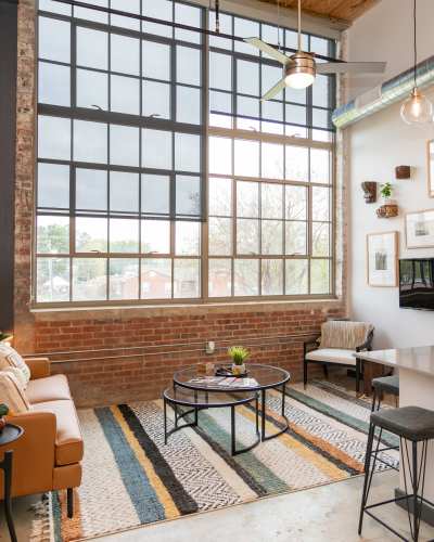 Large windows on a brick wall in living room at Mojud Lofts in Greensboro, North Carolina