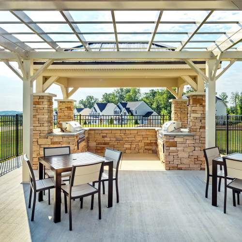 Outdoor lounge seating and grilling area at Rochester Village Apartments at Park Place in Cranberry Township, Pennsylvania