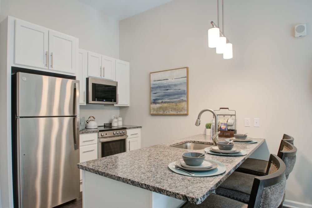Senior apartment kitchen with stone countertops at Crescent Fields at Huntingdon Valley in Huntingdon Valley, Pennsylvania