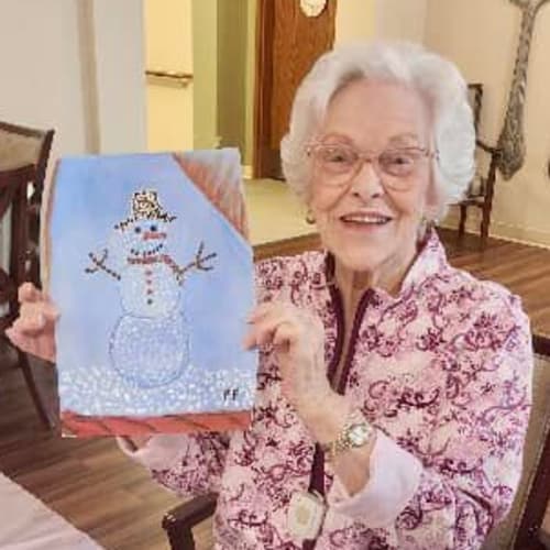 Sitting resident smiling at the camera inside The Oxford Grand Assisted Living & Memory Care in McKinney, Texas