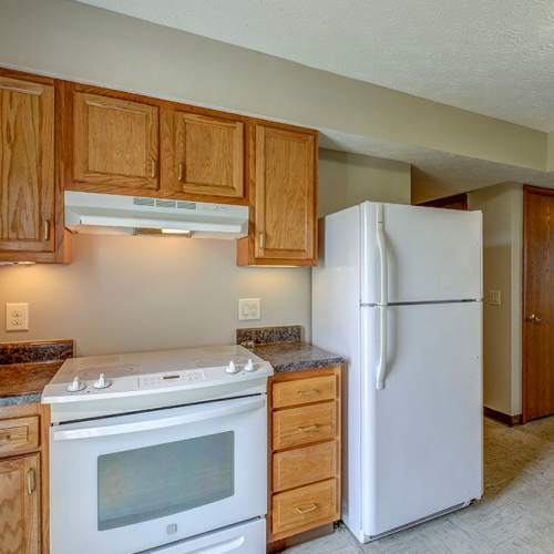 White refrigerator next to wooden cabinets at Orchard Glen in Orrville, Ohio