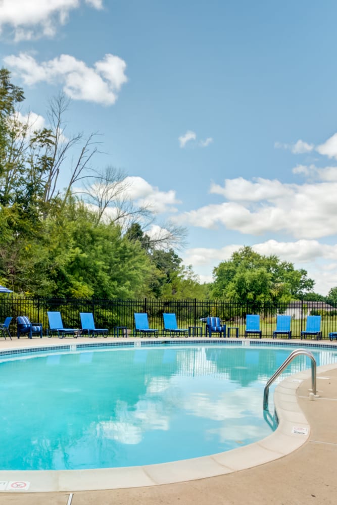 Swimming pool surrounded by lounge chairs at Montgomery Woods Townhomes in Harleysville, Pennsylvania