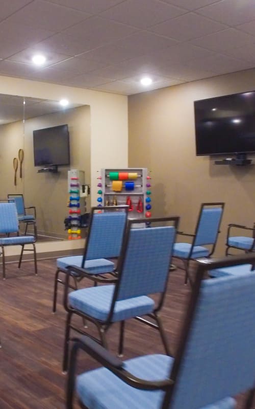 Resident recreation room with seating and large wall mounted television at The Pillars of Mankato in Mankato, Minnesota