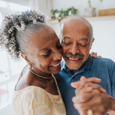 Resident couple dancing together in their independent living apartment at Cascade Park Vista Assisted Living in Tacoma, Washington