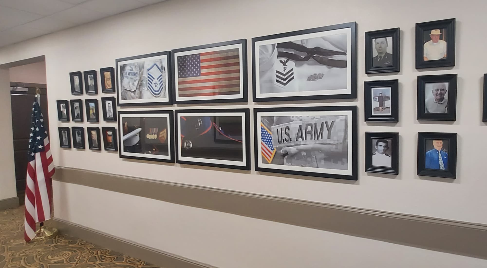 A hallway at The Landing featuring veteran memorial pictures and flags displayed on the walls.