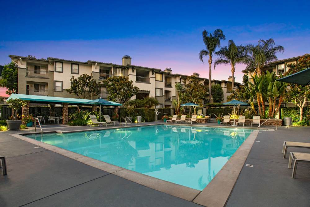 Beautiful pool and sundeck at Alicante Apartment Homes in Aliso Viejo, California at sunset