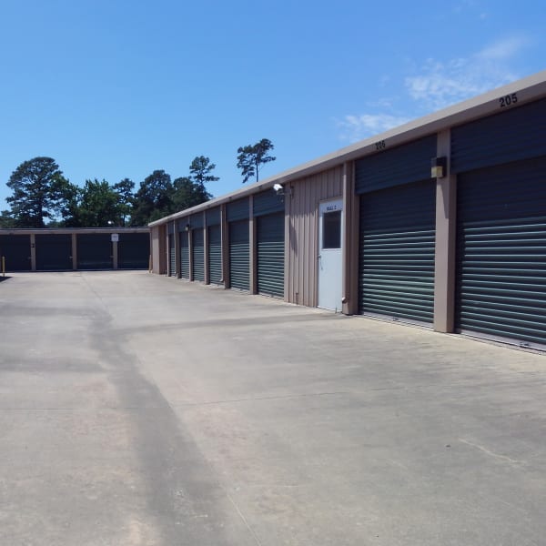 Outdoor storage units with green doors at StorQuest Self Storage in Spring, Texas