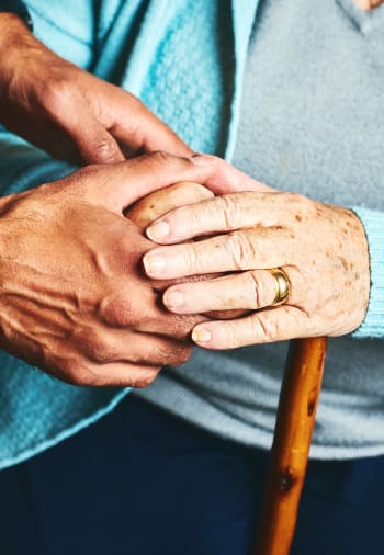 A resident and staff member holding hands at The Claiborne at Newnan Lakes in Newnan, Georgia. 