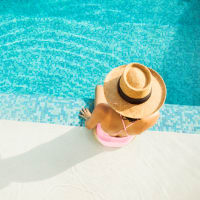 A woman sitting on the edge of the swimming pool at Ravella at Town Center in Jacksonville, Florida